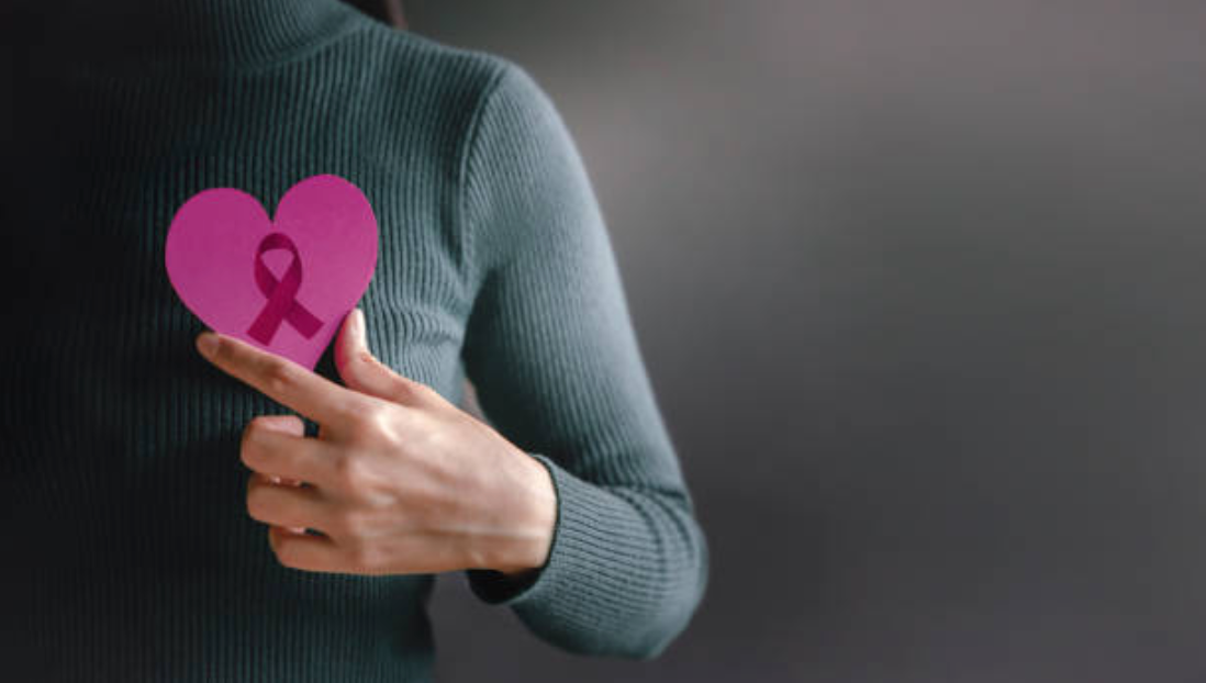 An image of a person holding a pink heart 